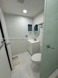 bathroom with tile patterned flooring, vanity, and toilet