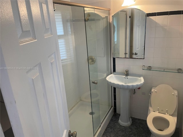 bathroom with an enclosed shower, tile patterned flooring, toilet, and tile walls