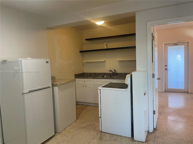 kitchen with white appliances, white cabinetry, and sink