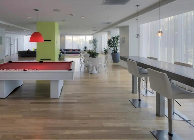 game room with hardwood / wood-style floors, a healthy amount of sunlight, and billiards