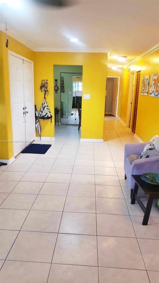 hallway featuring light tile patterned floors and ornamental molding