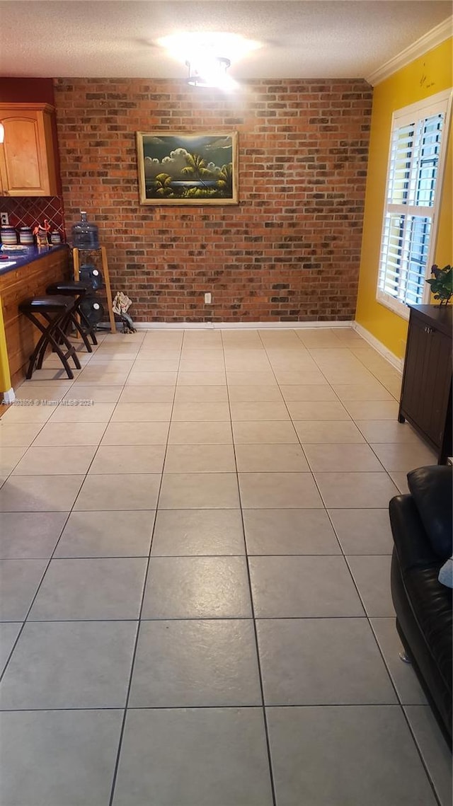 tiled living room with brick wall and crown molding