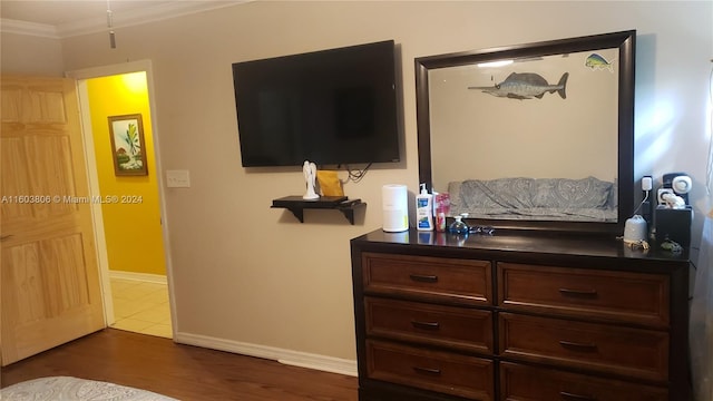 bedroom with dark hardwood / wood-style flooring and ornamental molding