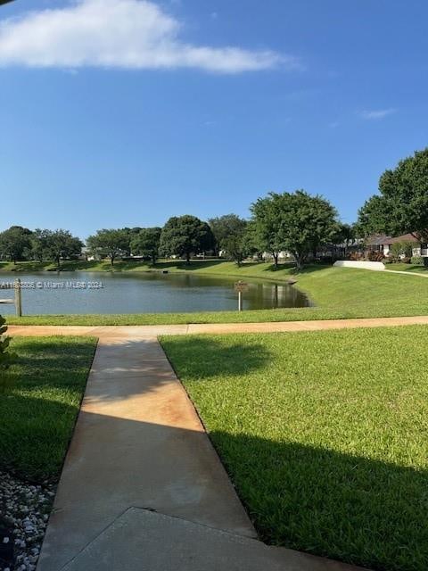 view of home's community featuring a water view and a lawn