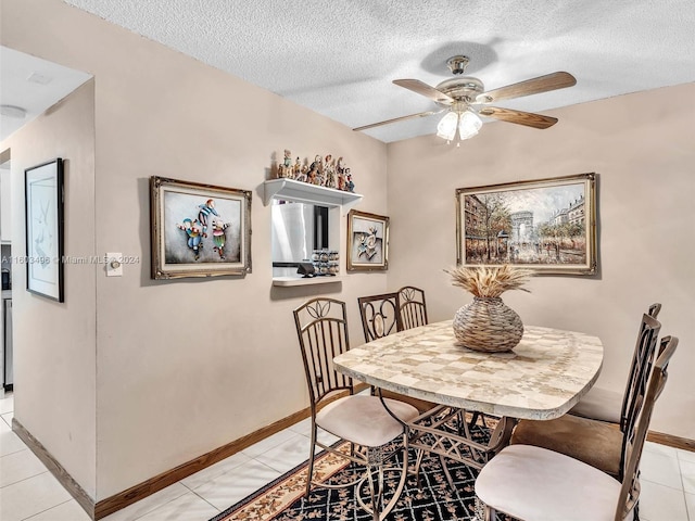 dining area with a textured ceiling, ceiling fan, and light tile patterned flooring