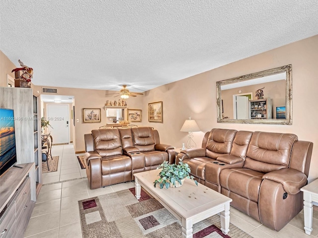 tiled living room featuring ceiling fan and a textured ceiling