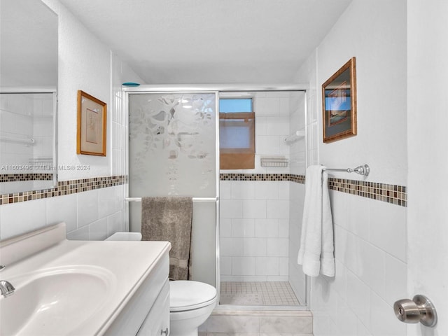 bathroom featuring vanity, toilet, an enclosed shower, and tile walls