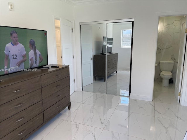 bedroom featuring ensuite bath, a closet, and ornamental molding