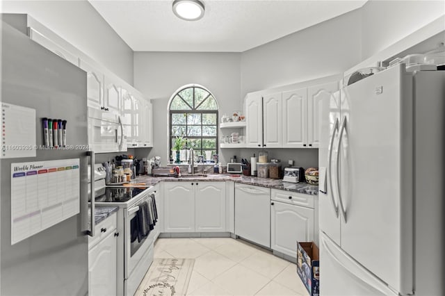 kitchen featuring light tile patterned flooring, sink, white cabinets, white appliances, and a textured ceiling