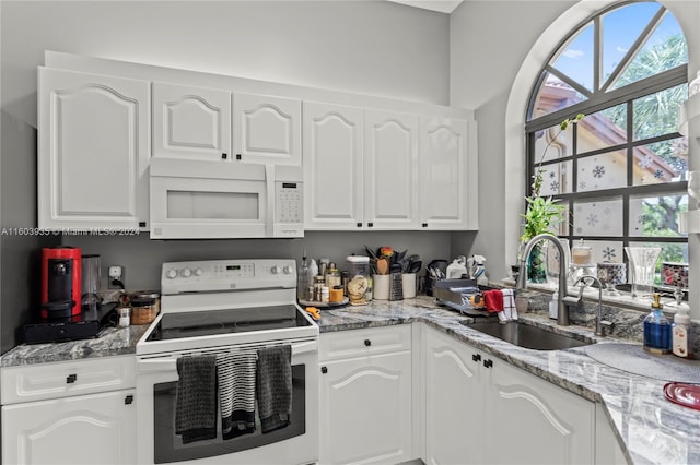 kitchen featuring white appliances, sink, and white cabinets