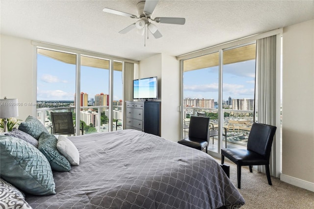 carpeted bedroom featuring a textured ceiling, access to exterior, and ceiling fan