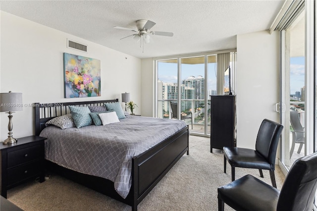 bedroom featuring a textured ceiling, ceiling fan, light carpet, and access to outside