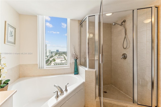 bathroom featuring shower with separate bathtub