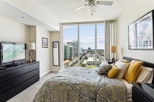 carpeted bedroom featuring a textured ceiling, ceiling fan, and multiple windows