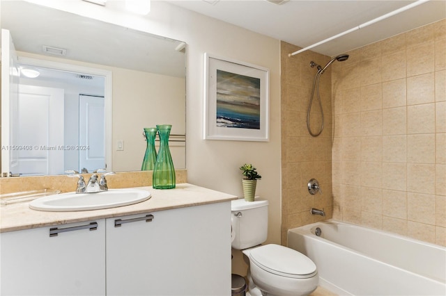 full bathroom with toilet, tiled shower / bath combo, and vanity