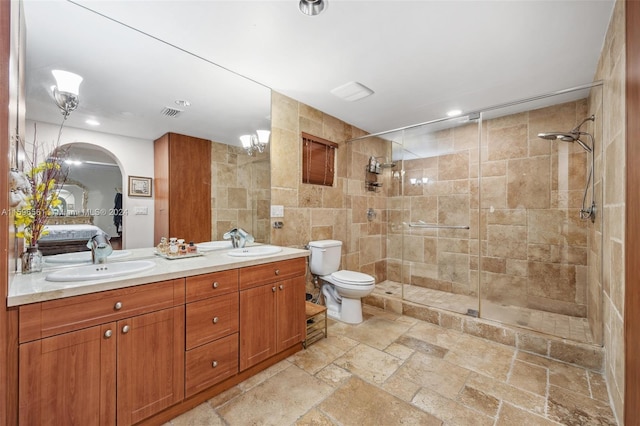 bathroom with toilet, vanity, and a shower with shower door