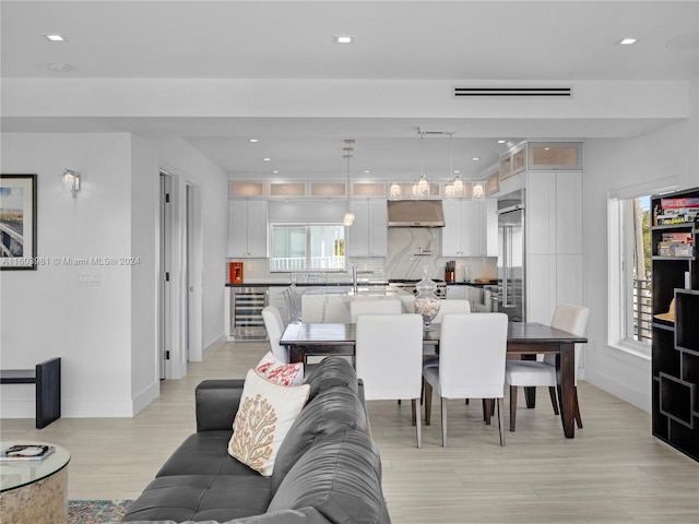 living room with wine cooler and light hardwood / wood-style flooring