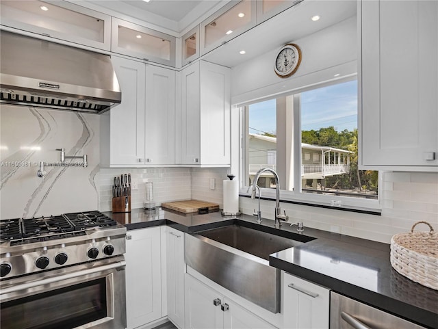 kitchen with backsplash, sink, stainless steel appliances, and white cabinets