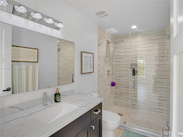 bathroom featuring walk in shower, vanity, and toilet