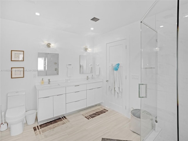 bathroom featuring vanity, toilet, a shower with door, and hardwood / wood-style flooring