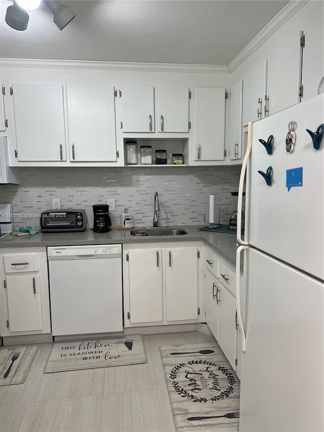 kitchen featuring white appliances, crown molding, backsplash, white cabinetry, and sink