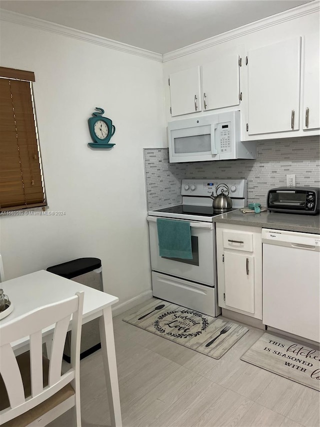 kitchen with backsplash, white cabinets, ornamental molding, and white appliances