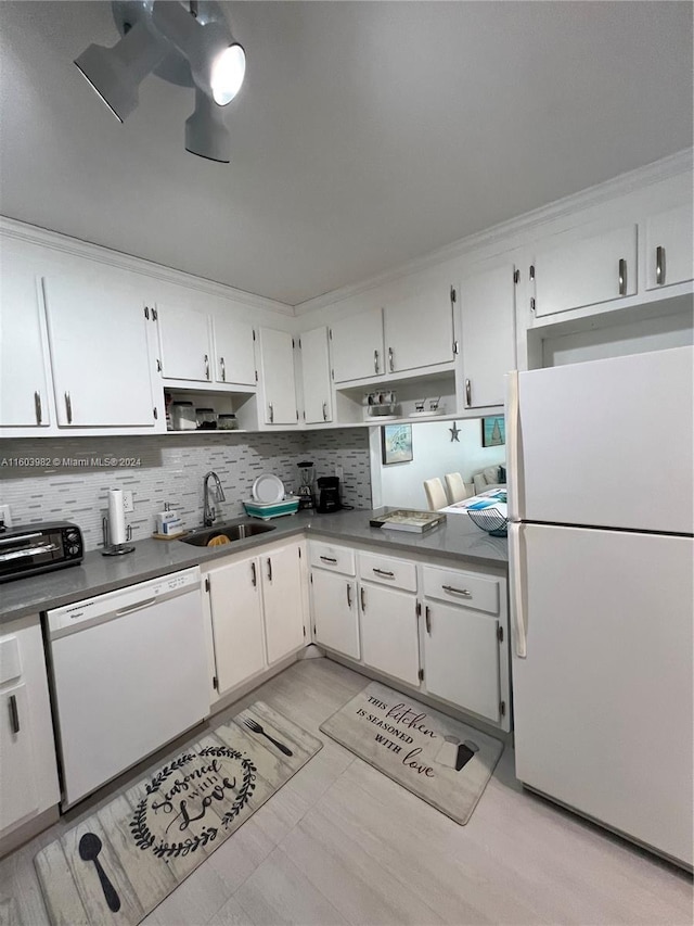 kitchen with white appliances, white cabinets, sink, tasteful backsplash, and ornamental molding