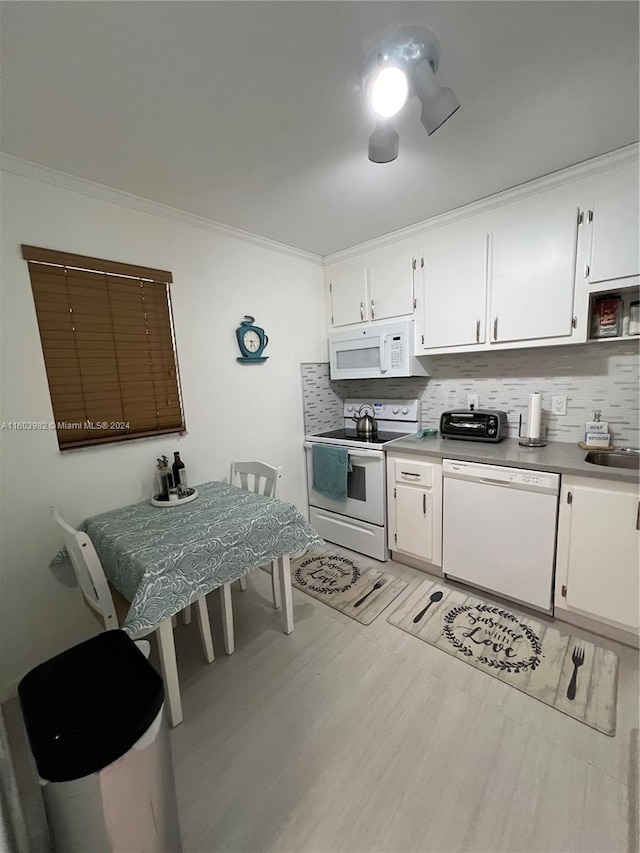 kitchen featuring backsplash, white appliances, crown molding, and white cabinetry