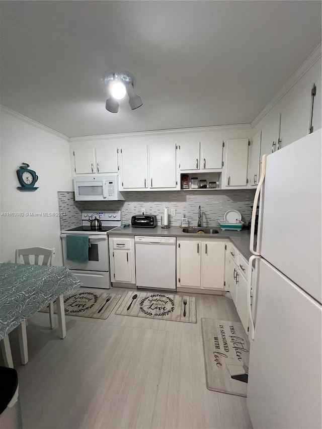 kitchen featuring white cabinets, sink, backsplash, and white appliances