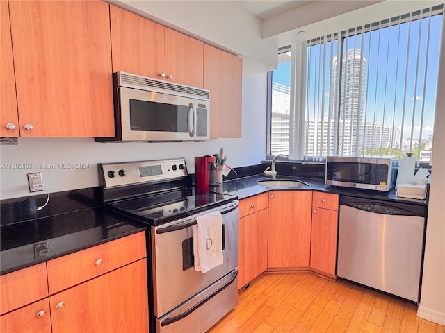 kitchen featuring appliances with stainless steel finishes, light wood-type flooring, and sink