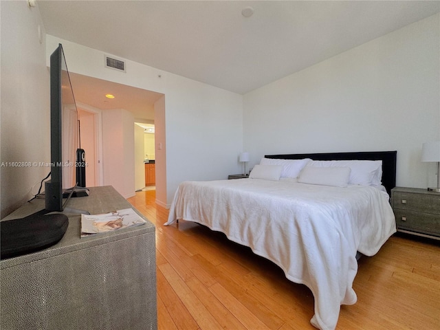 bedroom featuring light hardwood / wood-style flooring and connected bathroom