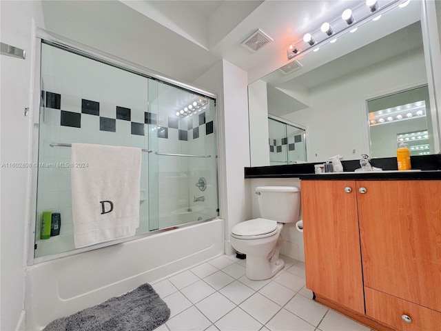 full bathroom with toilet, tile patterned floors, vanity, and bath / shower combo with glass door