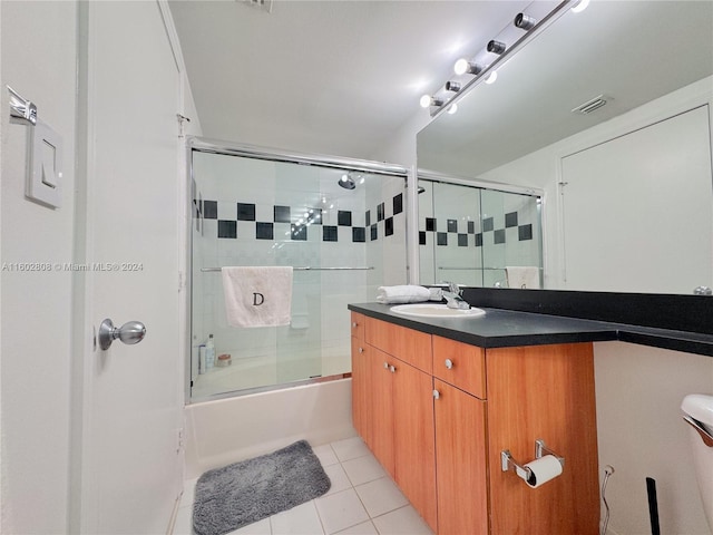 bathroom with tile patterned flooring, shower / bath combination with glass door, and vanity