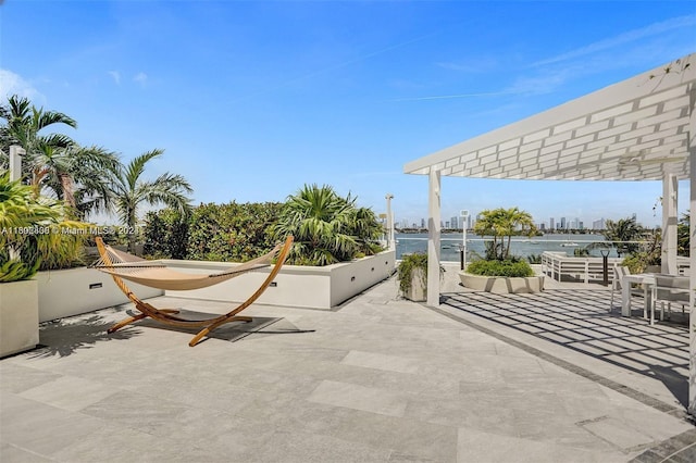 view of patio / terrace with a pergola and a water view