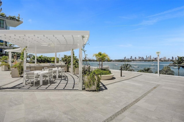 view of patio / terrace with a pergola and a water view