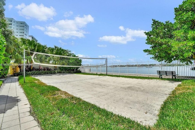 view of community with volleyball court and a water view