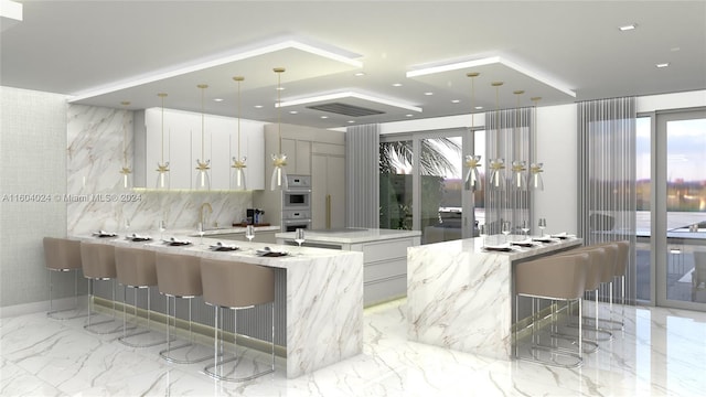 kitchen with white cabinetry, light stone countertops, a breakfast bar area, and pendant lighting