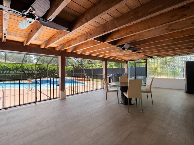 view of patio with a lanai, ceiling fan, and a fenced in pool