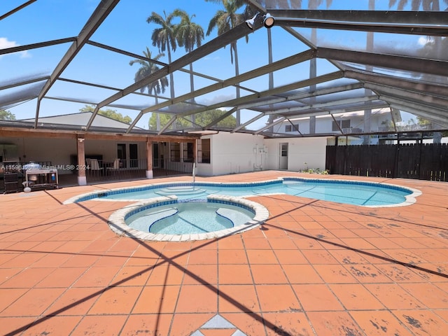 view of pool with an in ground hot tub, a lanai, and a patio area