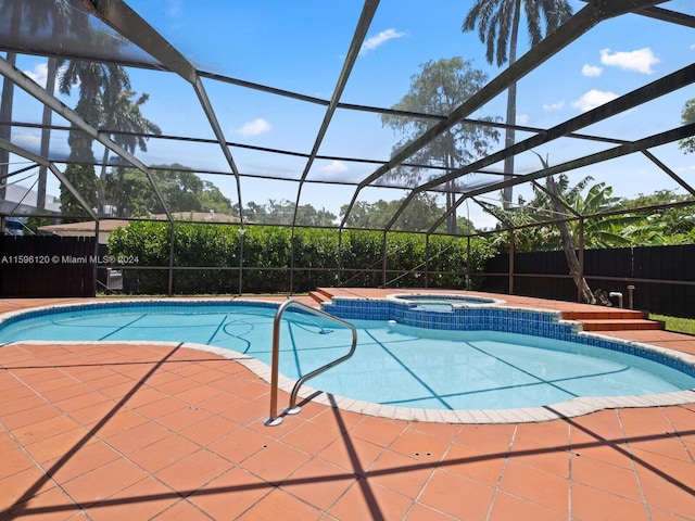 view of pool featuring glass enclosure and an in ground hot tub