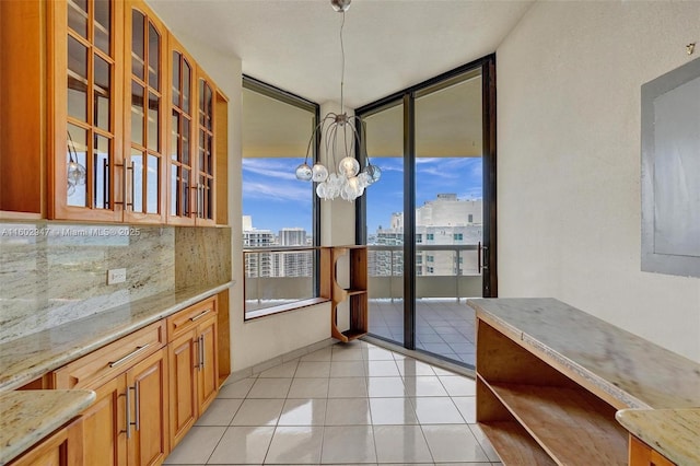 unfurnished dining area with an inviting chandelier and light tile patterned floors