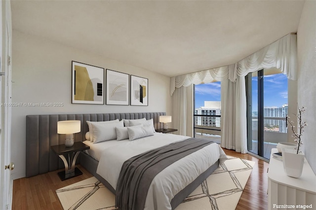 bedroom featuring access to exterior and hardwood / wood-style floors