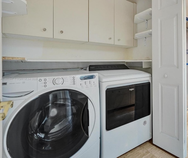 washroom featuring cabinets and washing machine and clothes dryer