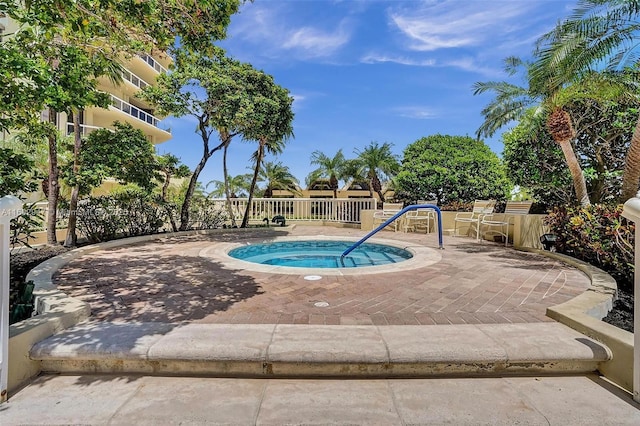 view of pool with a hot tub and a patio area