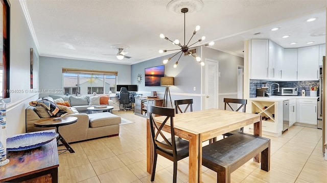 dining area featuring light tile patterned flooring, ceiling fan with notable chandelier, crown molding, and a textured ceiling