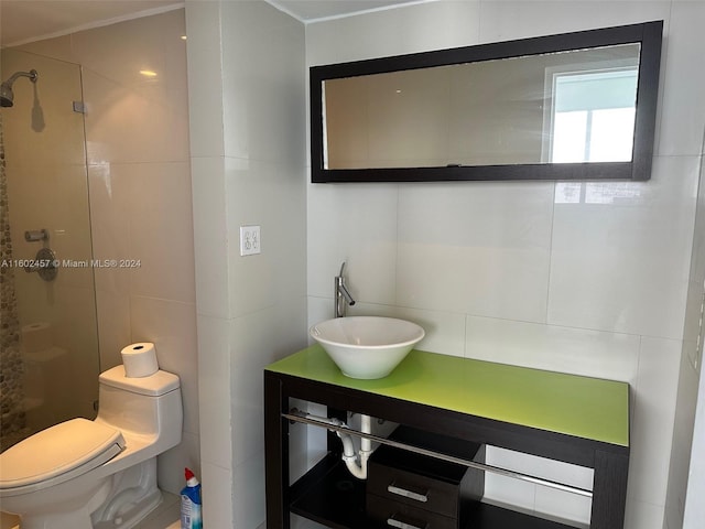 bathroom featuring tiled shower, toilet, and vanity