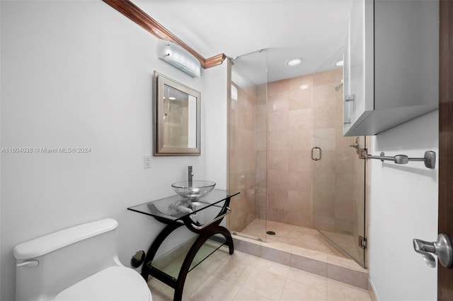 bathroom featuring sink, an enclosed shower, tile flooring, and toilet