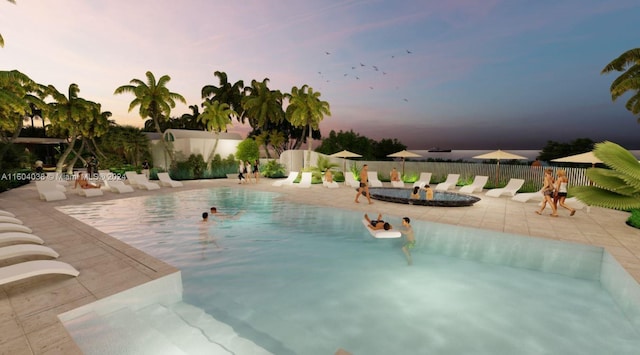 pool at dusk featuring a patio