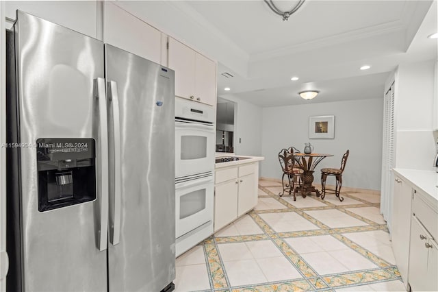 kitchen featuring white cabinets, black electric cooktop, stainless steel refrigerator with ice dispenser, white double oven, and a raised ceiling