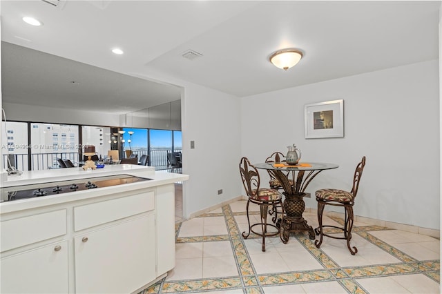 dining room with light tile floors and a wall of windows